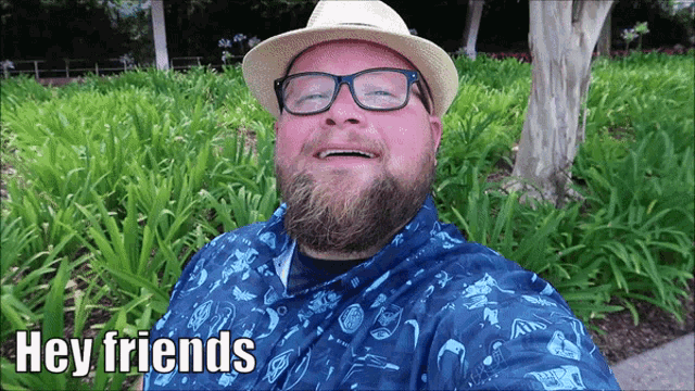 a man with a beard wearing a hat and glasses says hey friends