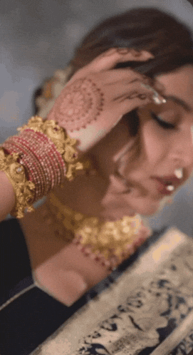 a close up of a woman 's face with henna on her hand