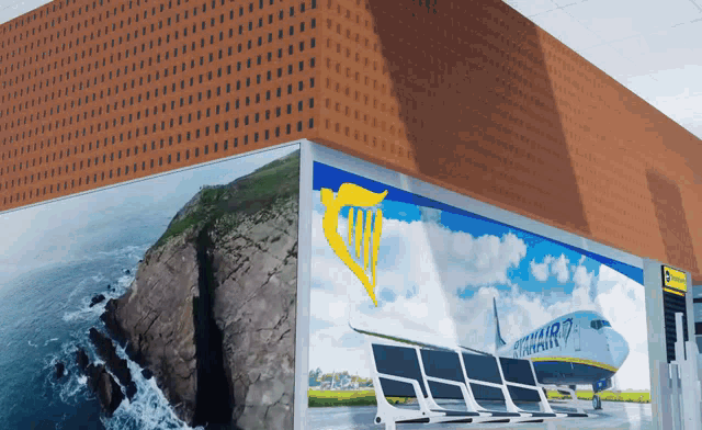 a ryanair plane is sitting on a runway in front of a cliff