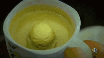 a close up of a cup of yellow liquid with the number 3 on the bottom