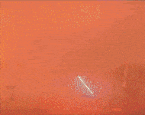 a group of people are walking through a foggy tunnel while a man holds a lightsaber .