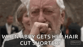 a man in a suit and tie is crying while holding his fist to his face .