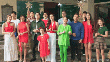 a group of people standing in front of a building with a giffun.com logo on the bottom