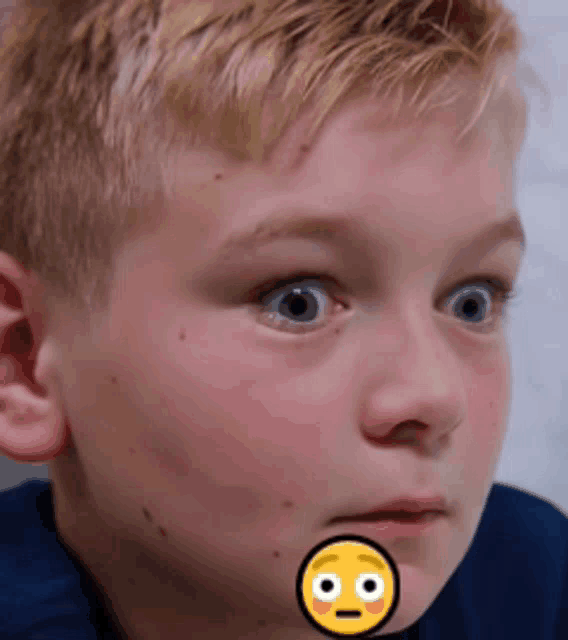 a young boy with a yellow smiley face on his face
