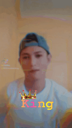 a man wearing a baseball cap and a white shirt with the word king on it