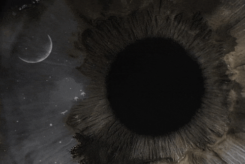 a crescent moon is visible in the sky above a dark eye