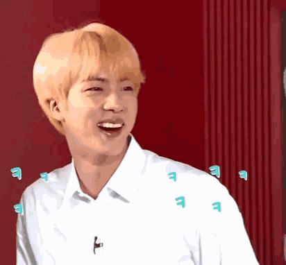 a young man with blonde hair and a white shirt is laughing