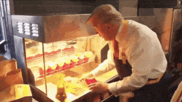 a man in a white shirt and tie is standing in front of a machine that says ' a ' on it