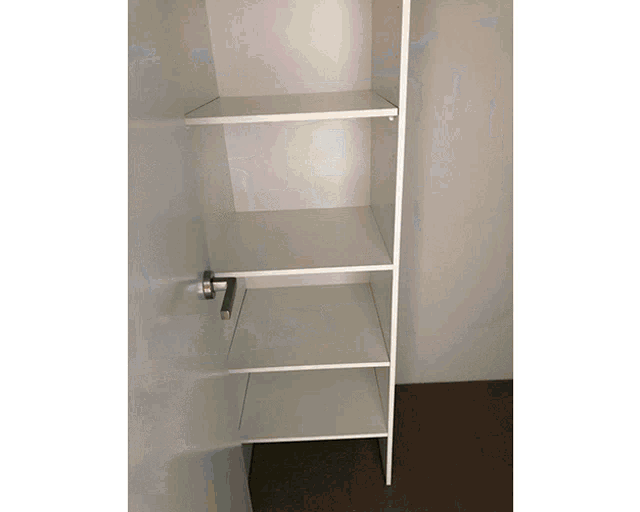a closet with empty shelves and a stainless steel handle