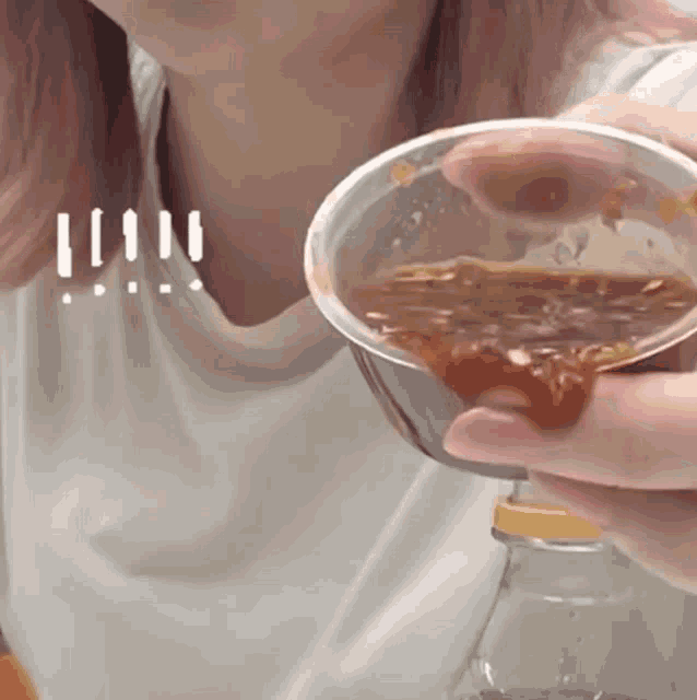 a woman is holding a cup of ketchup and a bottle of water