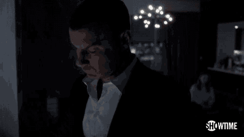 a man in a suit says " sure " in the dark