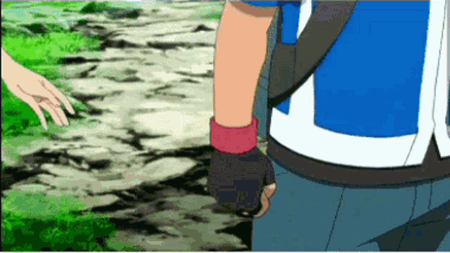 a man in a blue shirt is holding a woman 's hand while walking down a path .