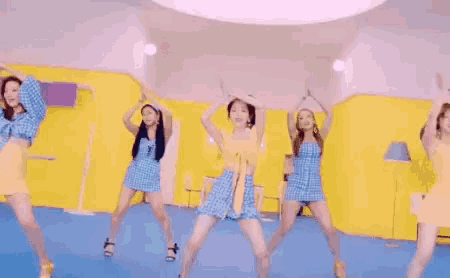 a group of young women are dancing together on a blue floor .