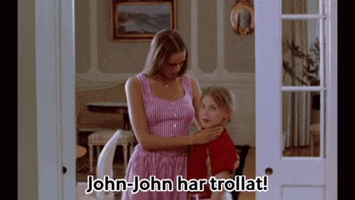 a woman in a pink dress holds a little girl in a room with the words john-john har trollat