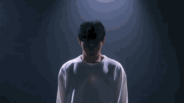 a man in a white shirt has a light shining from his chest
