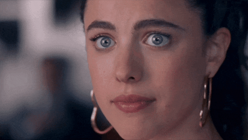 a close up of a woman 's face with a surprised look on her face