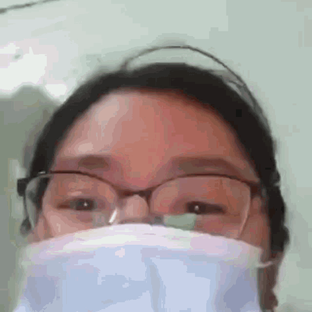 a close up of a woman wearing glasses and a mask .