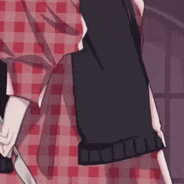 a close up of a person holding a knife in a plaid shirt .
