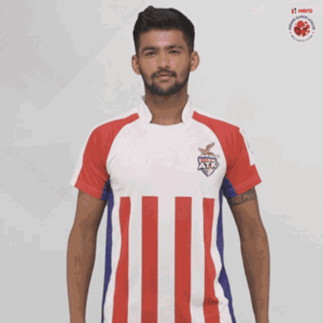 a man wearing a red white and blue striped shirt that says atk