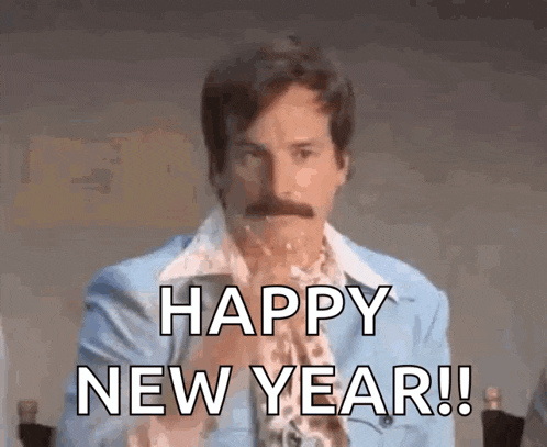 a man in a blue suit is holding a glass of champagne and says happy new year .