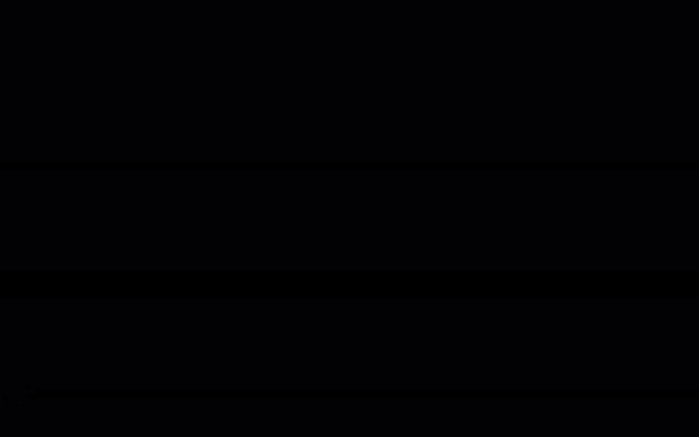 a man walking down stairs in a dark room with a light on