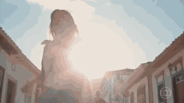 a woman walking down a street with the sun shining through her hair