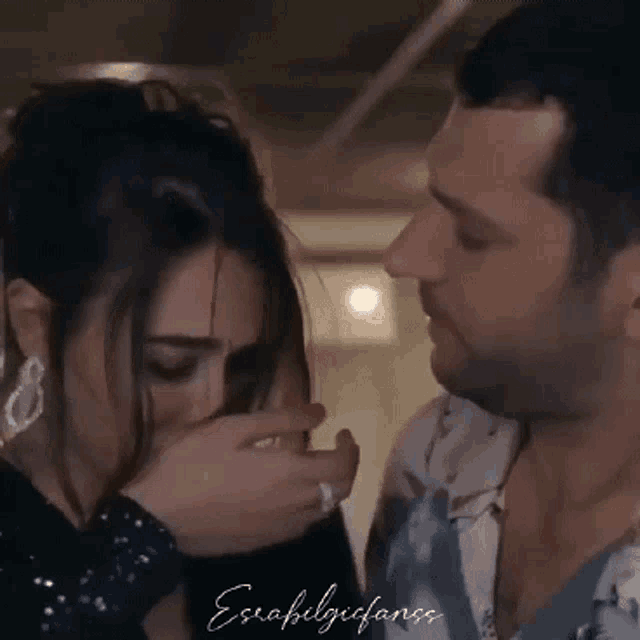 a man and a woman are looking at each other and the woman is covering her face .