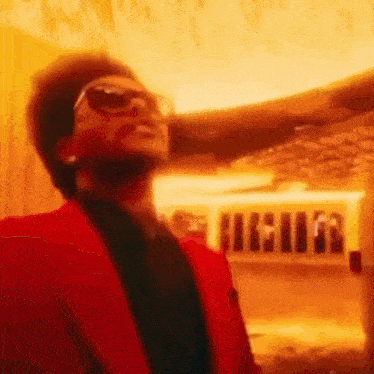 a man in a red suit is standing in front of a fire .