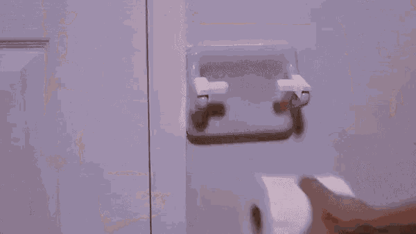 a close up of a person 's hand pressing a button on a toilet seat .