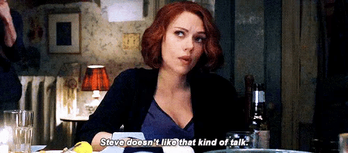 a woman is sitting at a table and talking to a man .