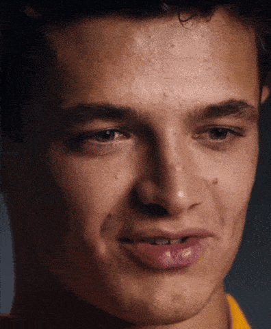 a close up of a young man 's face with a yellow shirt