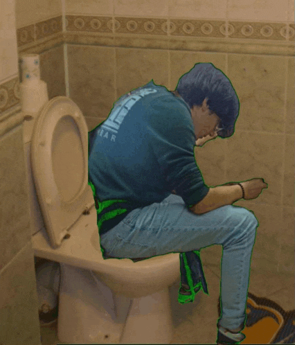 a man sitting on a toilet wearing a shirt that says ear on the back