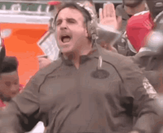 a man wearing a headset is screaming in a crowd
