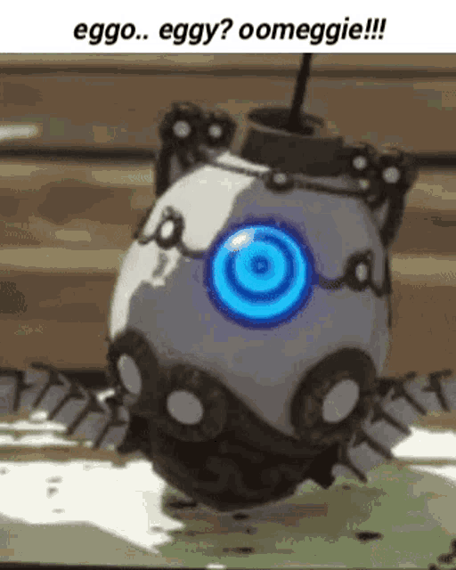 a white egg with a blue eye is sitting on top of a table .