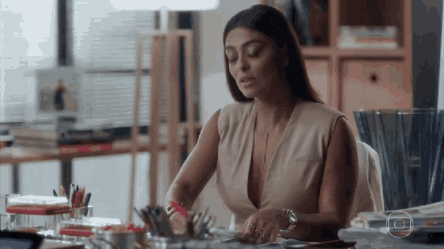 a woman is sitting at a desk with a plunging neckline and a watch .