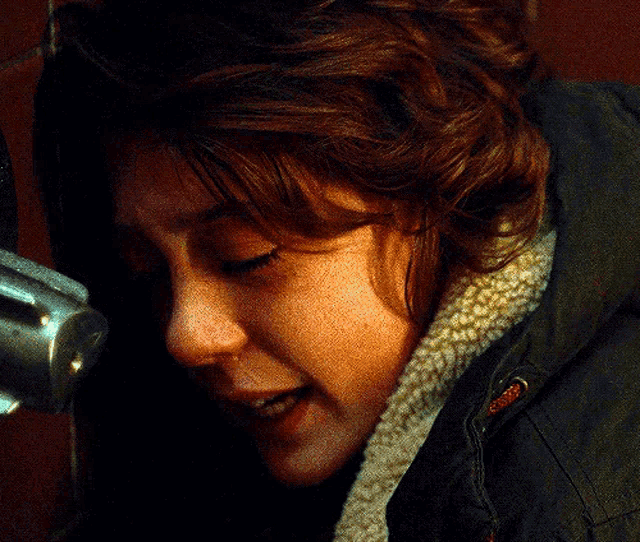 a close up of a woman 's face with a black jacket