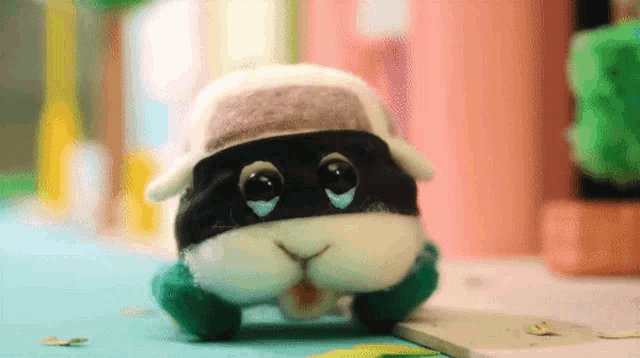 a stuffed animal wearing a hat and a mask is walking down the street .