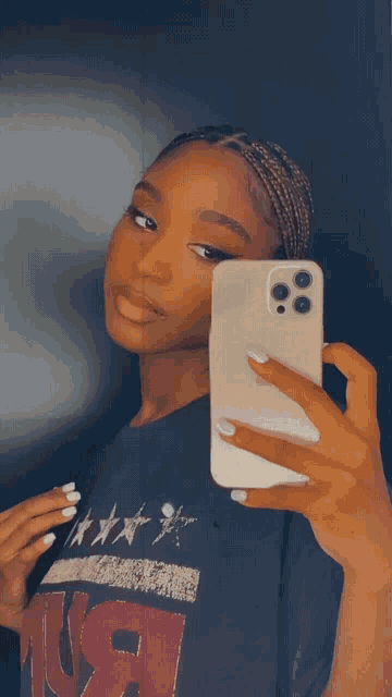 a woman taking a picture of herself in a mirror with her phone