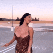 a woman in a leopard print dress is standing on a parking lot .