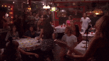 a group of people are gathered in a room with a sign that says ' a ' on it