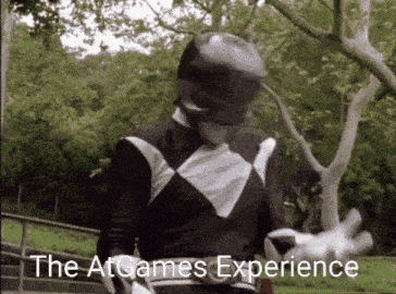 a black and white power ranger is standing in a park with the words " the at games experience " above him