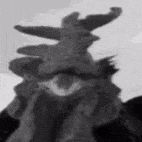 a black and white photo of a statue with a shadow of a person covering their face .