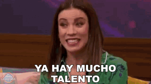 a woman is sitting on a couch and says ya hay mucho talento