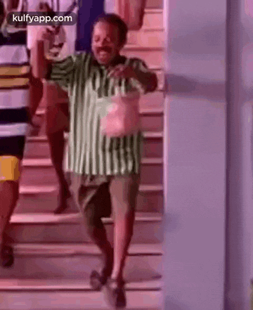 a man is dancing on a set of stairs while holding a bag .