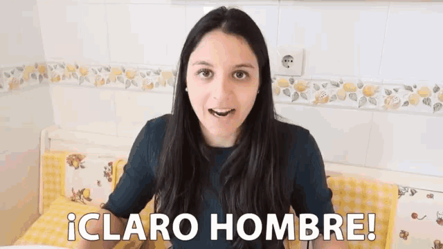 a woman sitting on a bed with the words claro hombre written on her chest