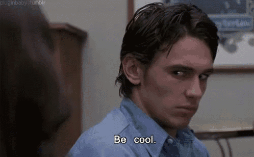 a man in a blue shirt is saying `` be cool '' while looking at a woman .
