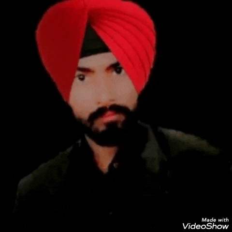 a man with a beard and a red turban is wearing a black shirt .