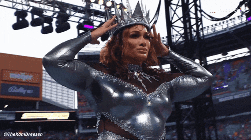 a woman with a crown on her head stands in front of a meijer building