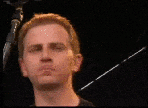 a man wearing a black shirt that says banned core is playing a guitar on stage