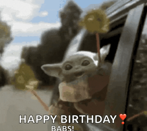 a baby mandalorian is sticking its head out of a car window and says happy birthday babs
